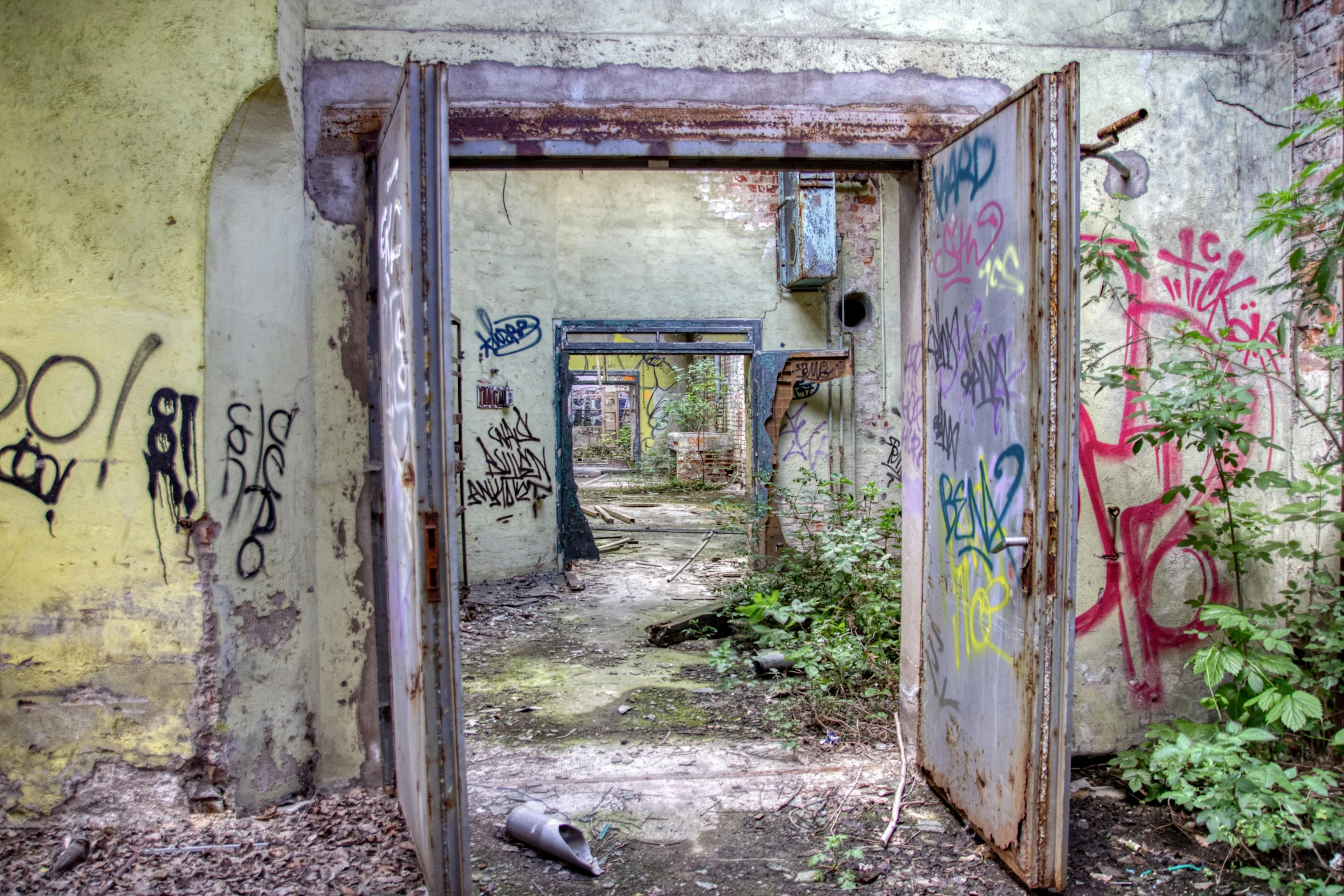 a door with graffiti is open in an old building