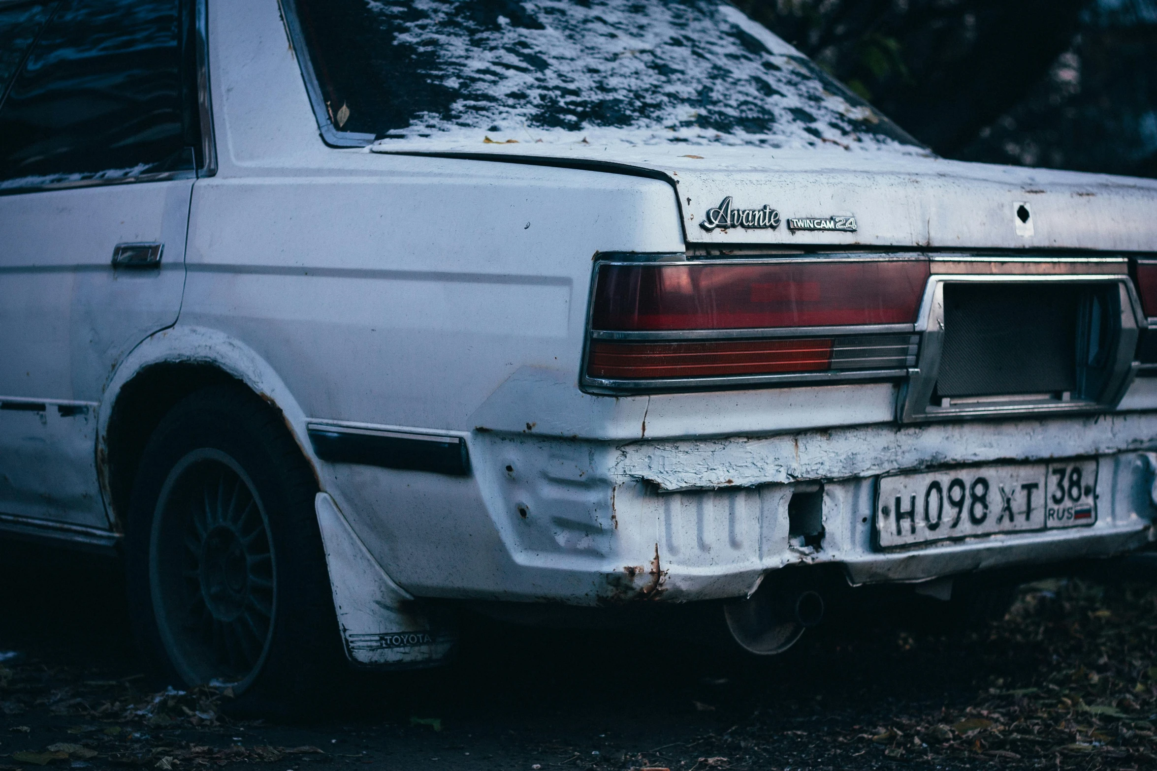 an old car is covered in snow on the ground