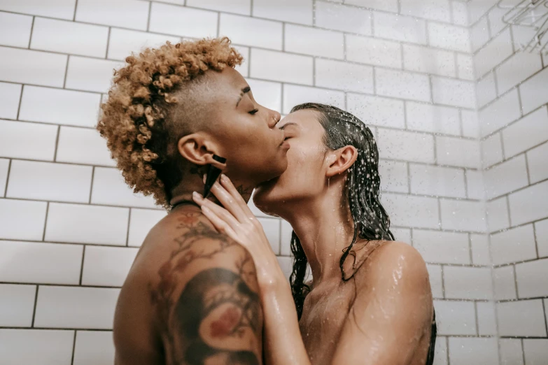 a black woman is kissing her boyfriend in the shower