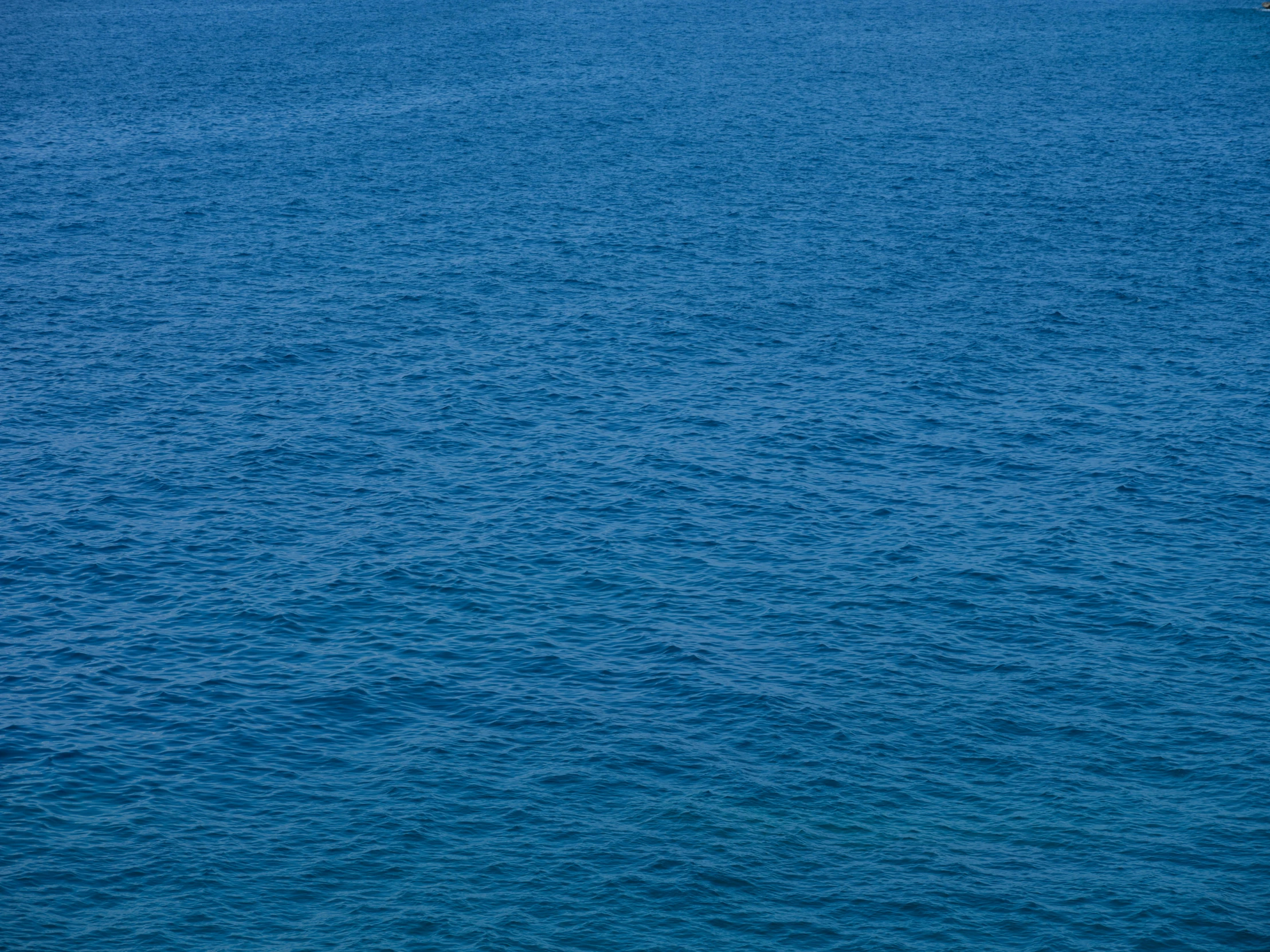 a lone boat on a blue body of water
