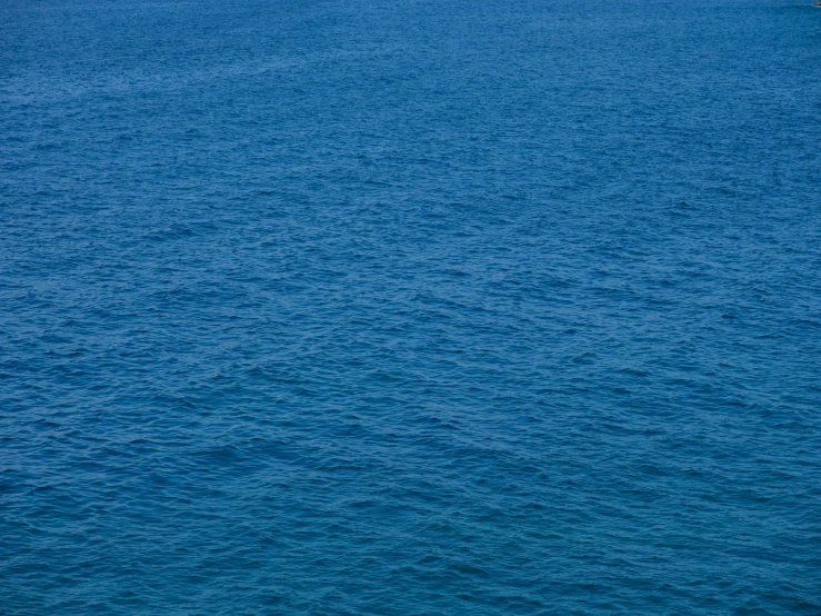 a lone boat on a blue body of water