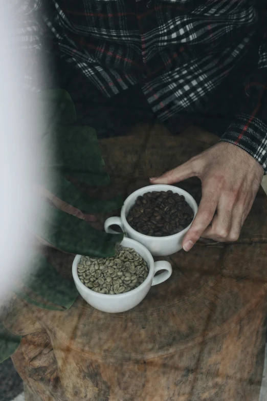 a person holding two small bowls filled with food