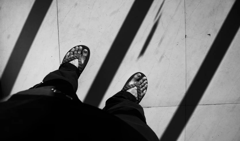 man with feet up in front of tiled wall