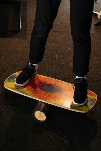 a man's feet stand on top of a skateboard