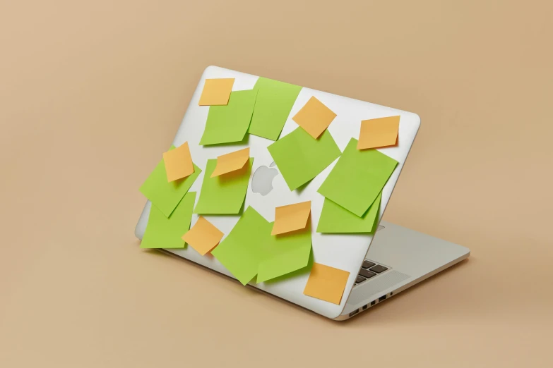 a laptop on a table with a bunch of sticky notes attached to the keyboard