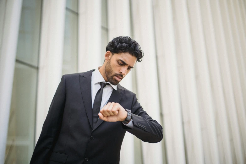 a man dressed in a suit is pointing his fist