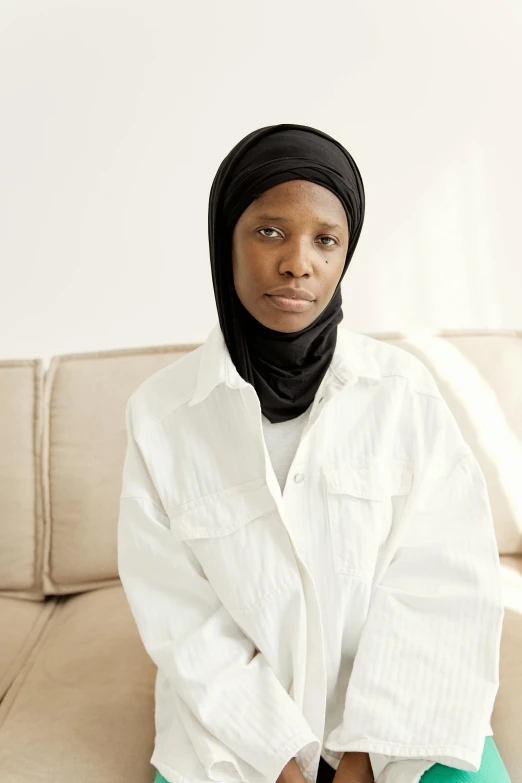 a woman in white shirt and green pants with a black hijab