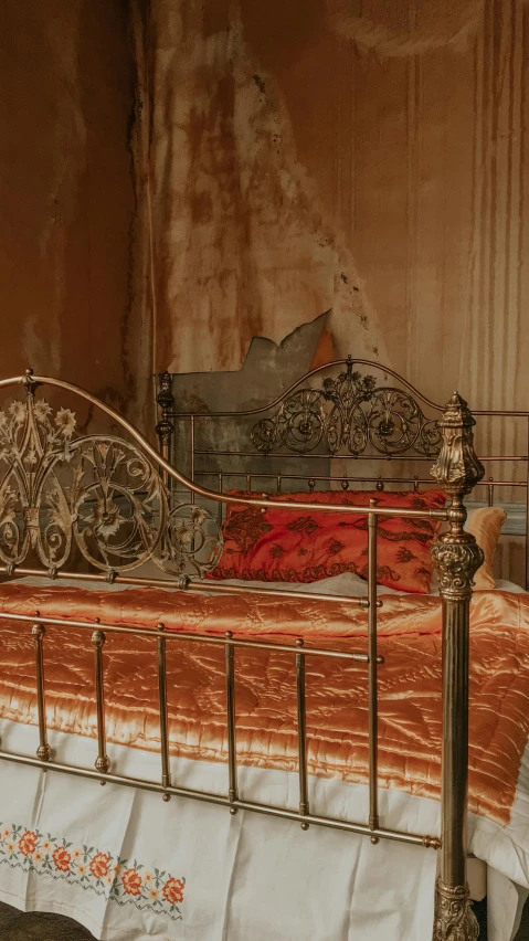 a bed with a red and gold bedspread and matching pillow