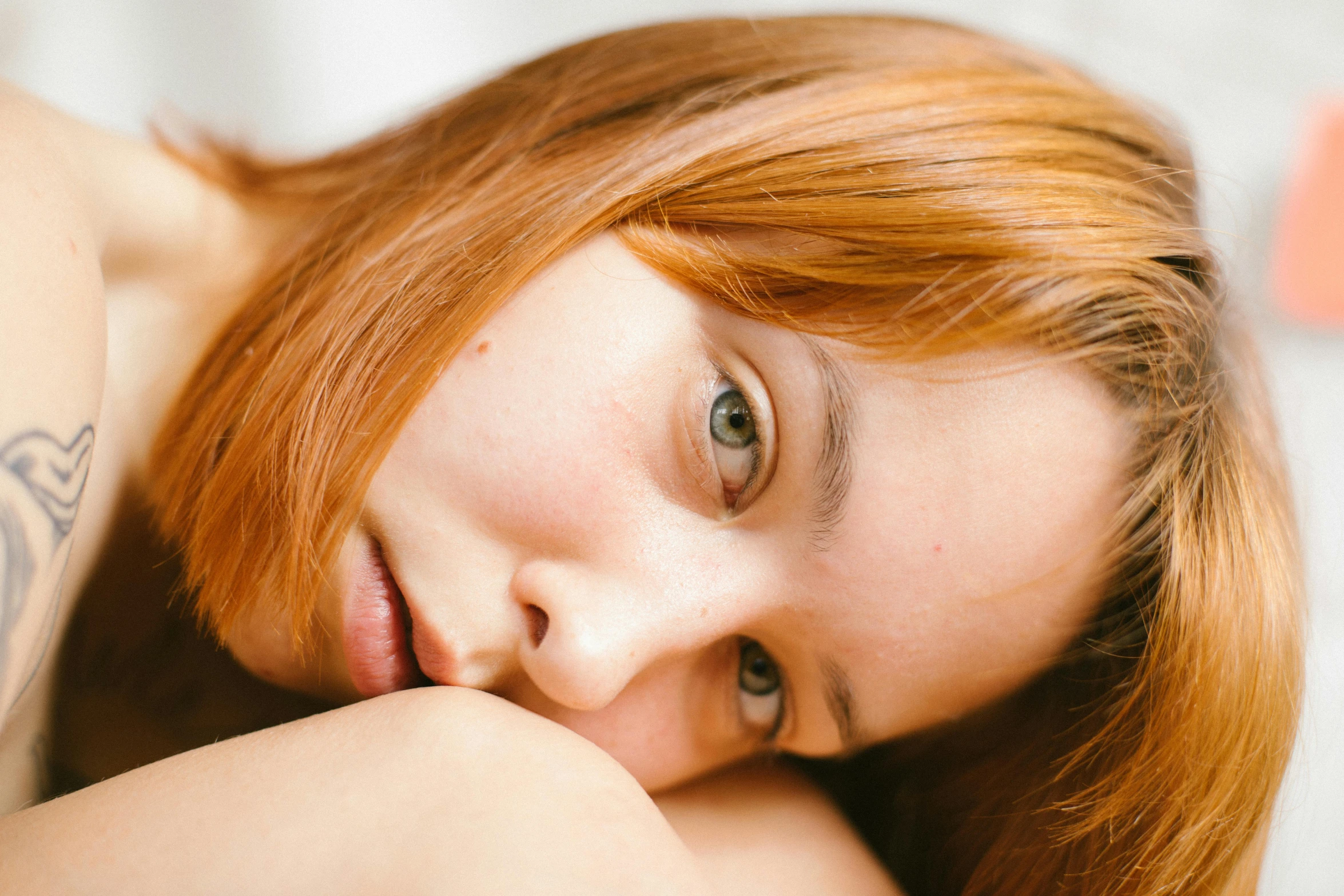 a close up of a woman with red hair and tattoos