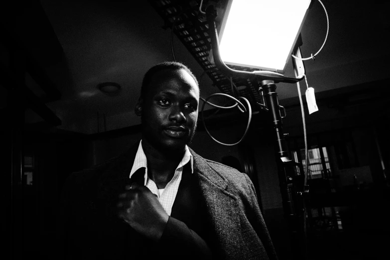 man standing by camera and light in dark room