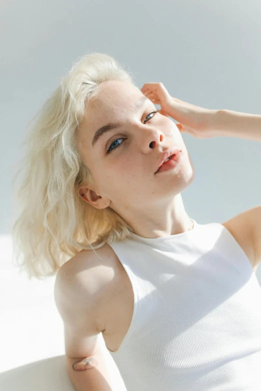 blonde haired woman posing with hand on her head