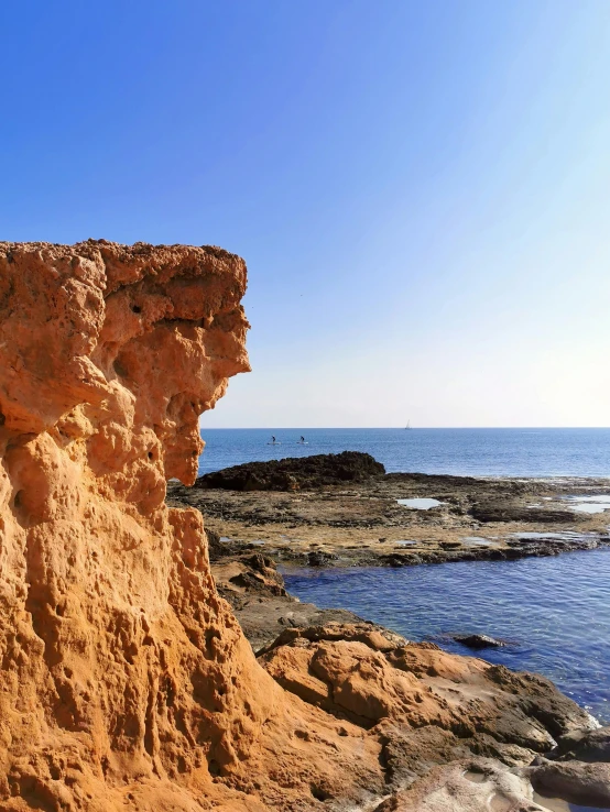 an image of a red cliff out on the beach