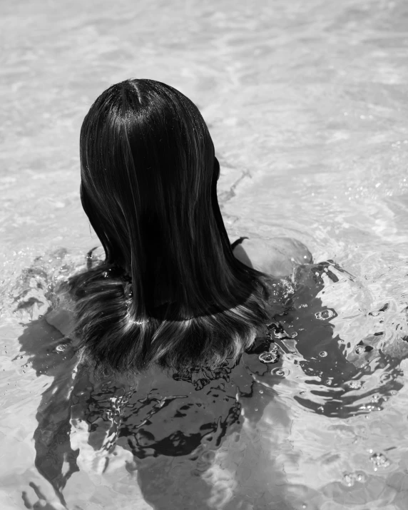 black - and - white pograph of a woman in the water