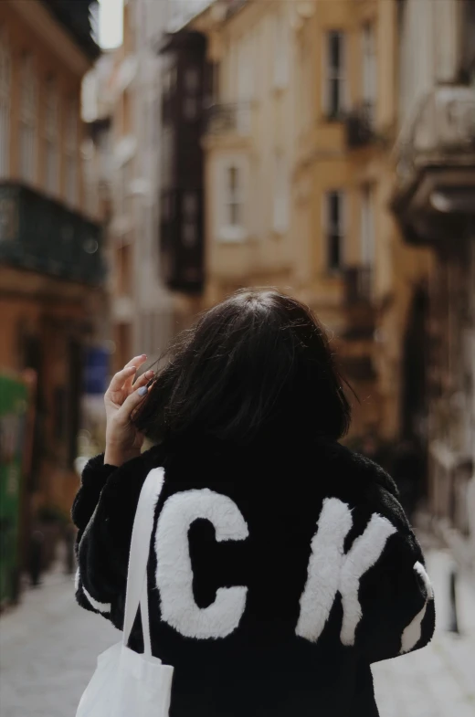 woman walking down the street wearing a black and white jacket