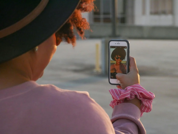 a woman taking a po with her cell phone of a man