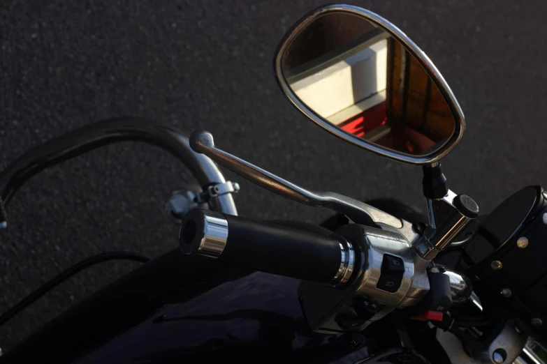 a motorcycle parked next to a road with a side mirror