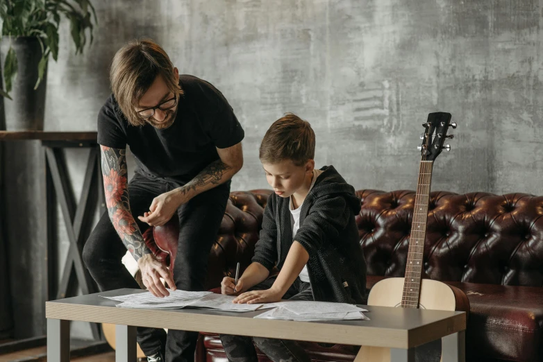 man and child in living room working on a guitar