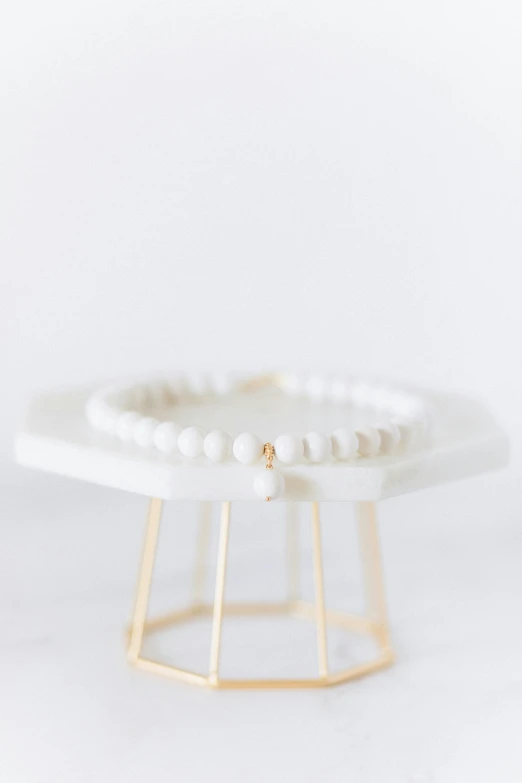 a single beaded ring on a metal stand