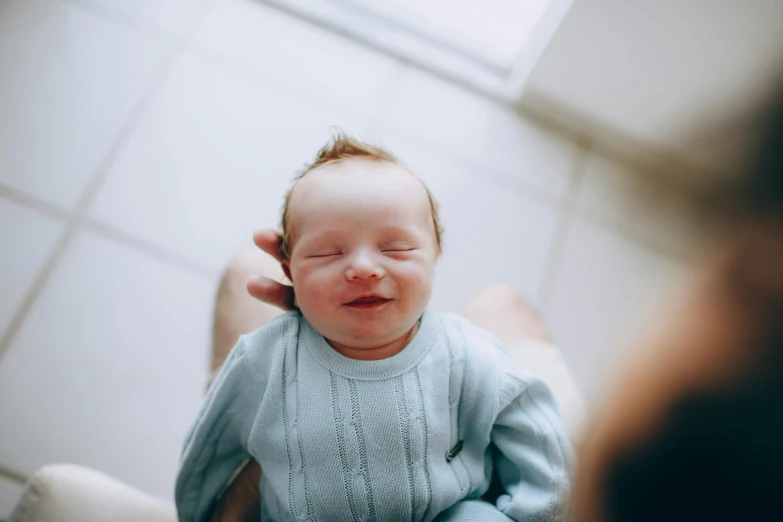 a baby being held by a woman in a bathroom