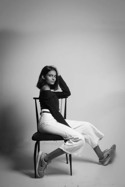 a beautiful young woman sitting in a chair