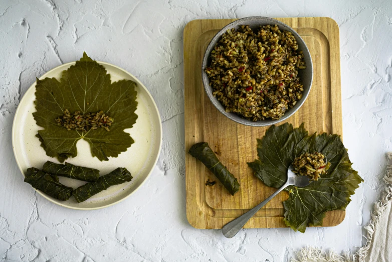 an overhead view of a bowl with gs, greens and dried leaf