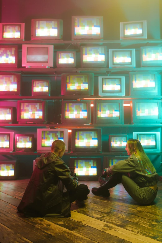 a couple sitting on the floor of a multicolored room