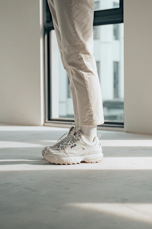 someone in white sneakers walking towards an open window