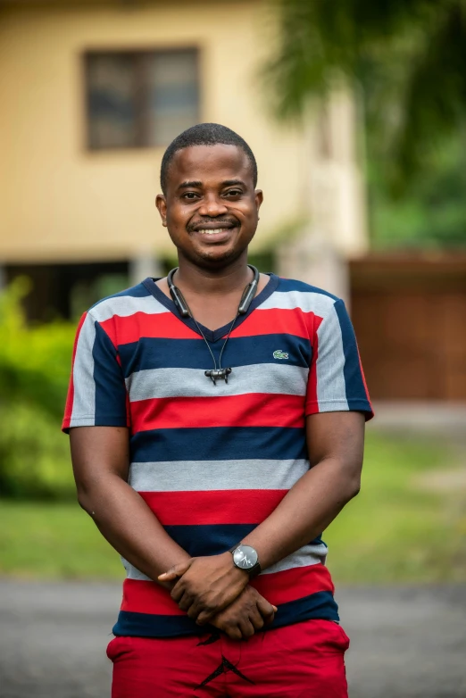 a man standing in a street and smiling at the camera