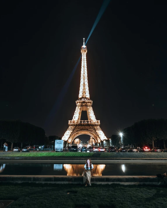 a person is standing by a body of water and the eiffel tower