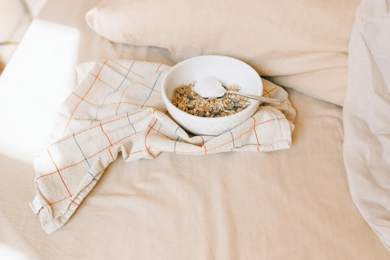 a bowl on the bed with some cereal and water