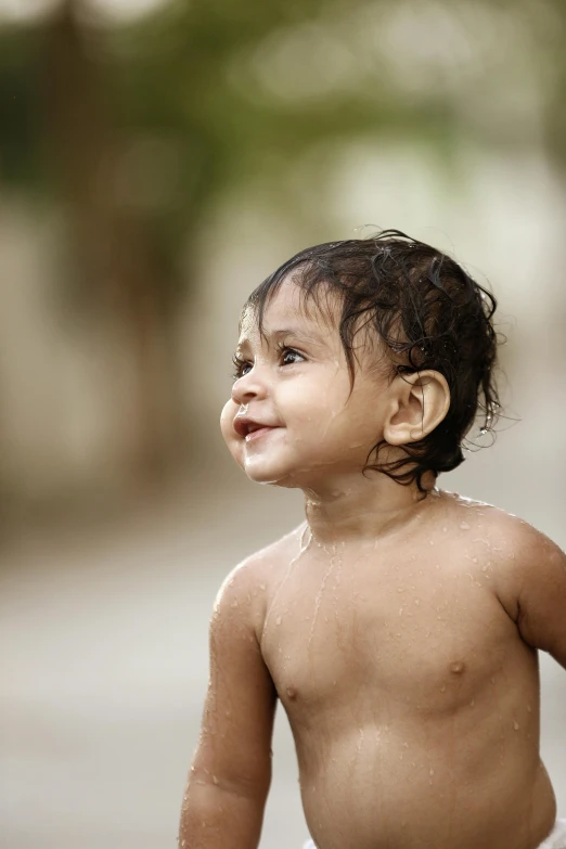 a young baby girl standing on a sidewalk