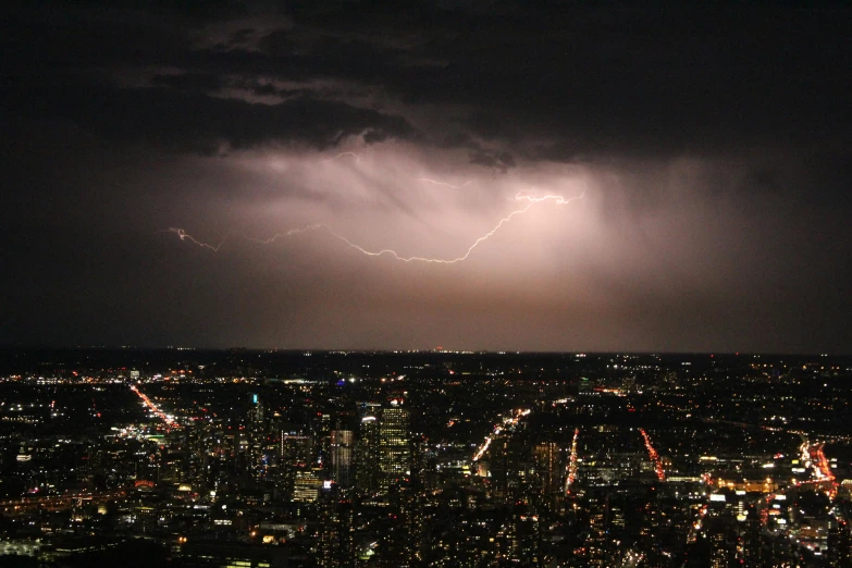 a city at night with lightning striking above