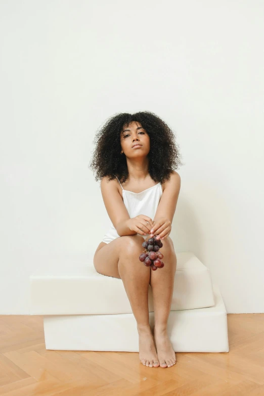 a woman with curly hair and black shoes sitting on a bench