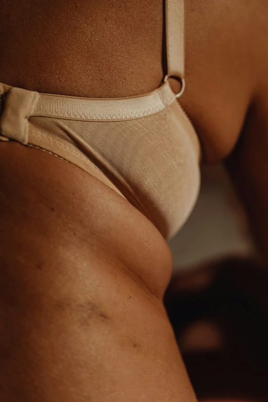 the bottom of a women's tan colored bikini with a ribbon