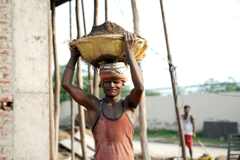 a man carrying a wooden basket on his head