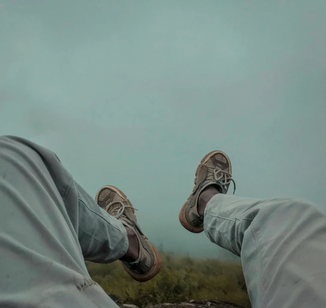 a persons feet wearing white sweatpants and sneakers