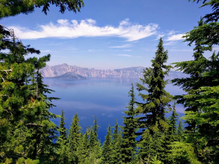 the blue waters are surrounded by trees and hills