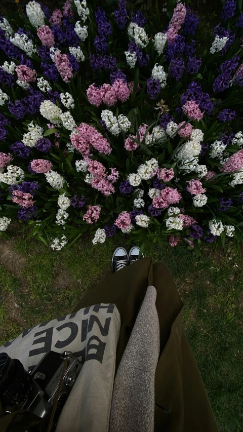 the view from underneath of someones feet and a bunch of flowers