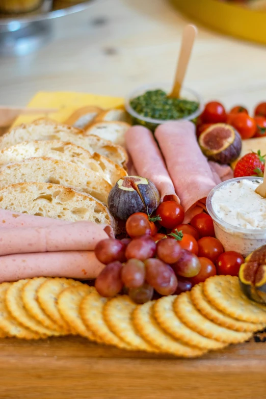 a plate of meat, bread, gs, ers and fruit is seen