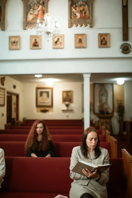 two women are sitting in pews and reading books