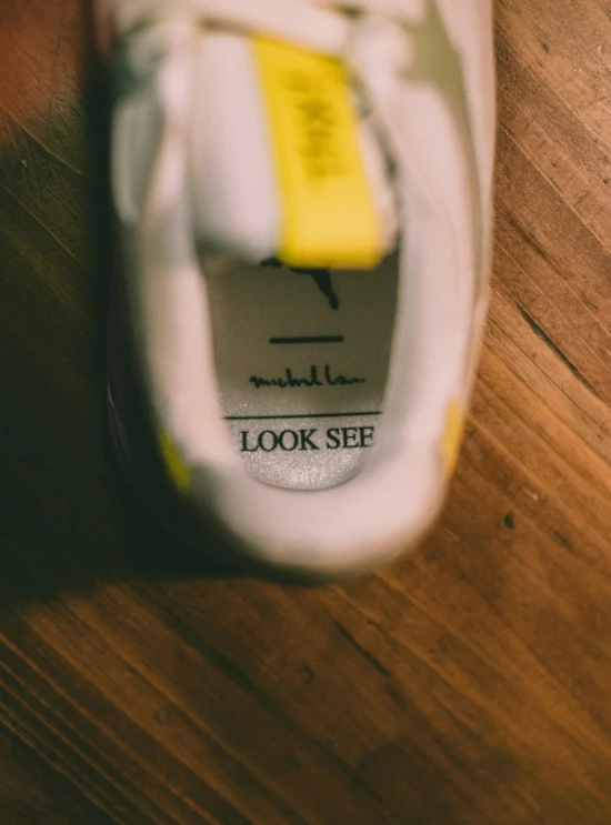 a shoe with yellow and white stripes is on the ground