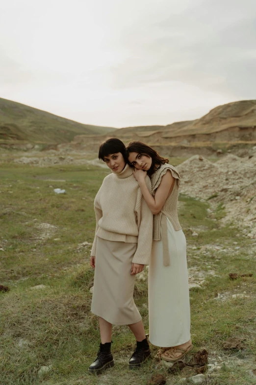 two young women standing together in the grass