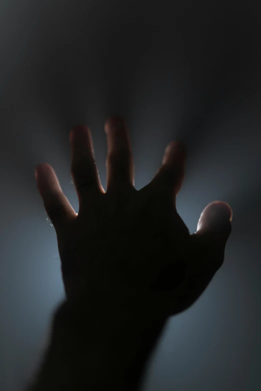 a person's hands up in the dark