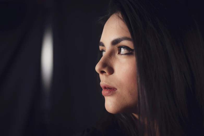 a woman with dark hair wearing a black dress