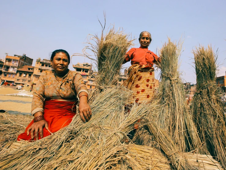 a woman and a man are standing among several types of straw