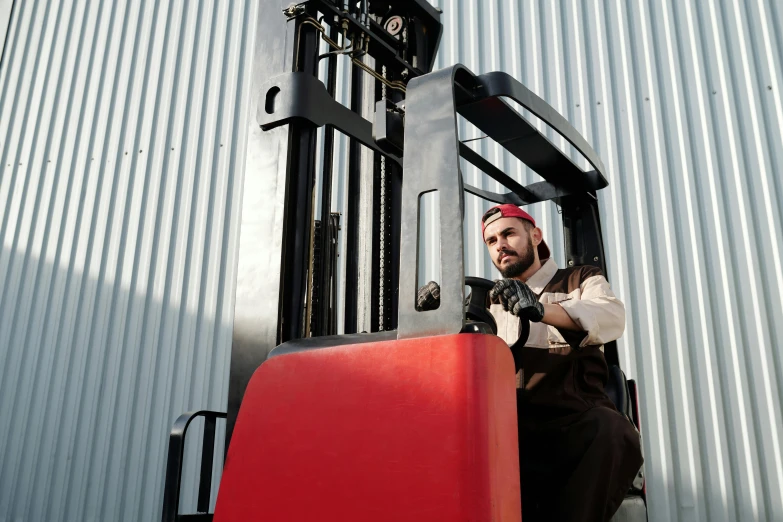 a man with a red tie is standing by the forklift