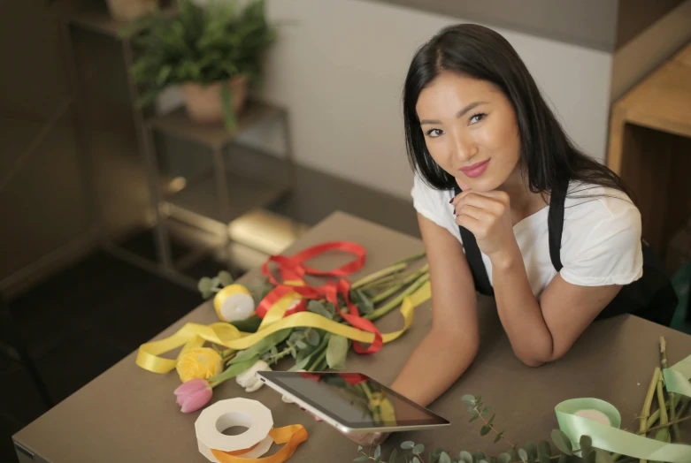 young woman posing next to various items on the table