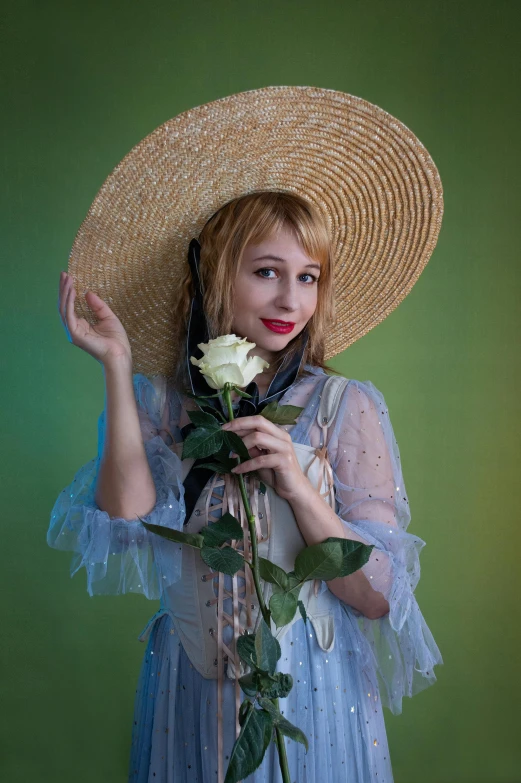 a woman is wearing a hat and holding flowers