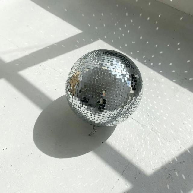 a silver ball is sitting on the white floor