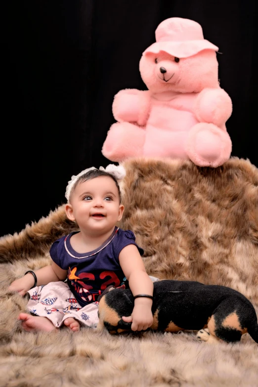 a baby is posing for a picture with a teddy bear